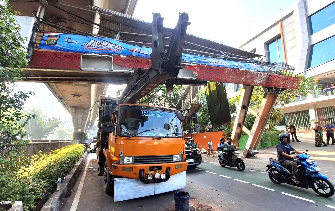 Foto editorial untuk berita Sopir Main Ponsel, Truk Pengangkut Alat Berat Tersangkut di JPO Tendean